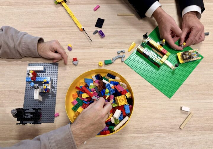 En fasilitator fra Sysint setter rammene for en workshop med LEGO® Serious Play® metoden. Deltagerne bygger individuelle modeller før de deles i gruppen. Vi fasiliterer strategiprosesser, teambuilding, lederutvikling, konseptutvikling og komplekse problemløsninger i grupper fra 6 til 200 deltagere.